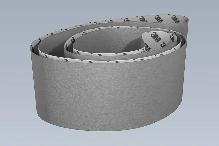 Long closed sanding belt against a plain background