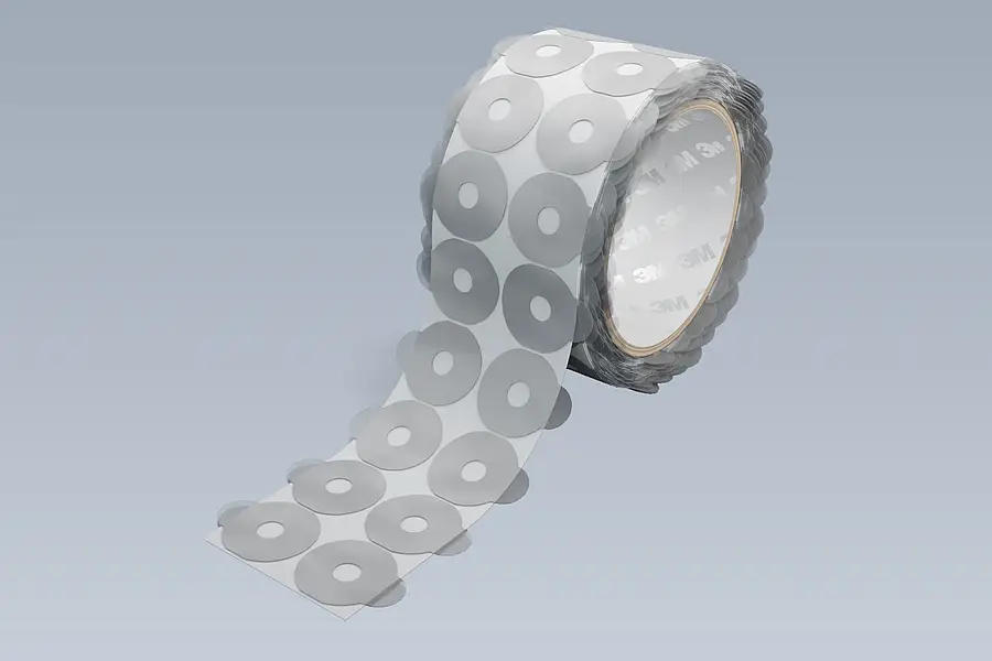 A roll of die-cut parts with visible pull tabs