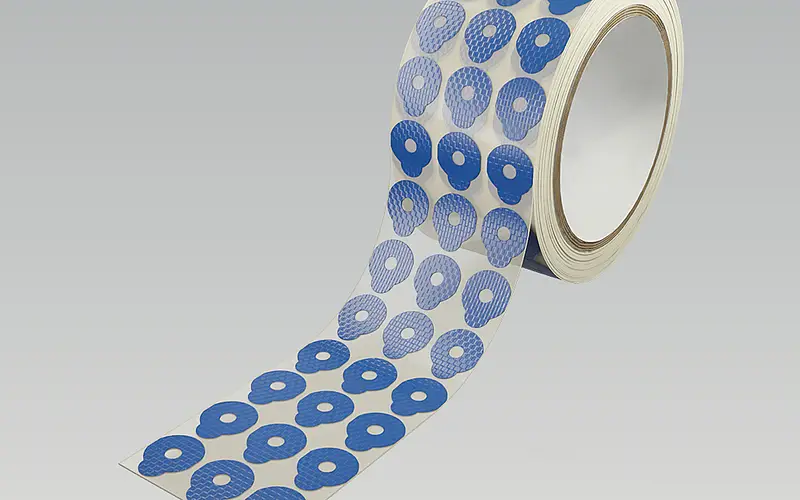 Roll of differently shaped adhesive die-cut parts on a carrier web