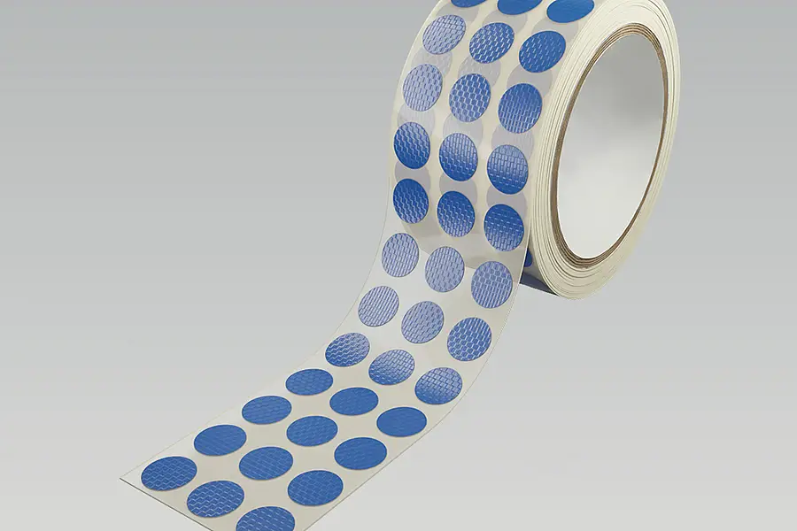 Roll of round adhesive die-cut parts on a carrier web